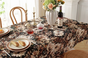 Detail of vintage black floral jacquard tablecloth with tassel in an elegant dining setting