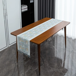 Modern geometric chenille table runner with colorful triangular patterns and tassel beads