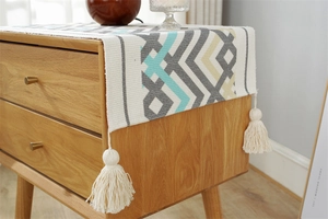 Detail of woven fabric dust cover with geometric patterns and thick cotton tassels
