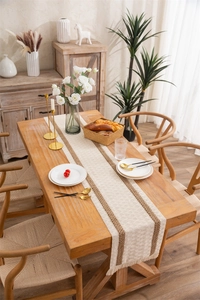 Detail of woven linen table runner featuring brown stripes and delicate fringe edges