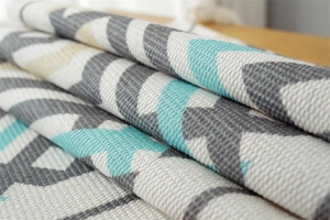 Close-up of chevron pattern woven dust cover with mint green and grey textures