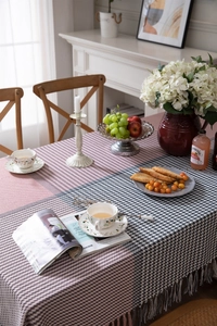Detailed view of houndstooth and pink striped tablecloth with elegant tassel edges