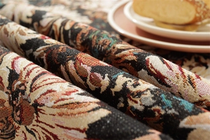 Close-up of vintage black daisy jacquard fabric with detailed floral woven texture