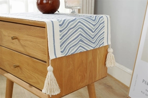 Macro detail of Nordic blue woven dust cover with wave patterns and handmade white tassels