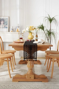 Detail of black crochet lace table runner with hollow geometric patterns and fringe
