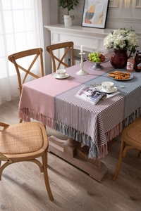 Detailed view of pink and black houndstooth tablecloth with fringed tassels and texture