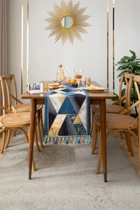 Detail of luxury geometric jacquard table runner with blue and gold tassels