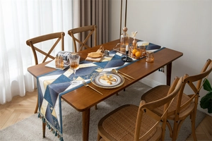 Detail of blue and gold geometric jacquard table runner with decorative tassels