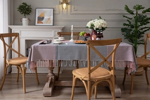 Close-up of pink houndstooth tablecloth with elegant fringe tassel details and soft texture
