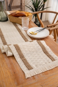 Detail of bohemian cotton linen table runner with woven tassels and diamond pattern