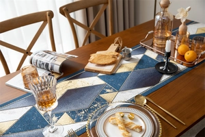 Detailed view of jacquard table runner with blue and gold geometric diamond patterns