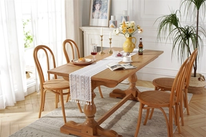 Detail of bohemian ivory lace table runner with hollow crochet patterns and fringe tassels