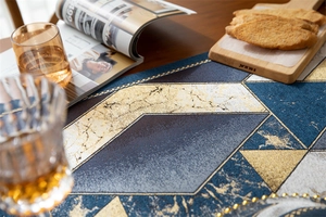 Macro detail of geometric jacquard table runner with metallic gold thread and blue patterns