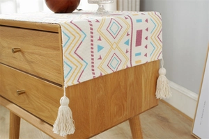 Detail of bohemian printed dust cover cloth with geometric patterns and white tassels