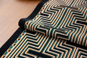 Macro detail of geometric jacquard table runner fabric with modern fringe and maze patterns