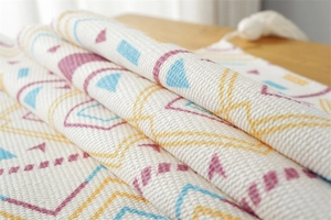 Close-up of geometric jacquard dust cover with multi-color patterns and tassel fringe