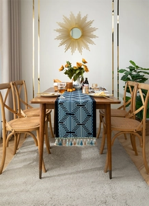 Detail of navy blue geometric jacquard table runner with handmade colorful tassels