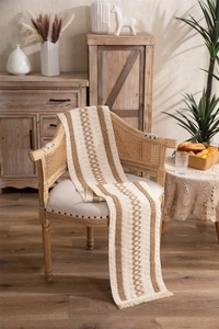 Close-up of bohemian linen table runner with brown wave embroidery and fringe details