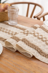 Detailed macro view of woven linen table runner with geometric fringe pattern