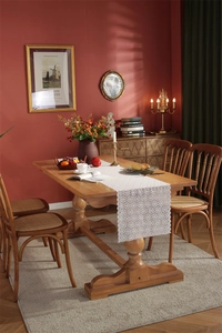 Close-up of white floral lace table runner with intricate hollow patterns on wood table