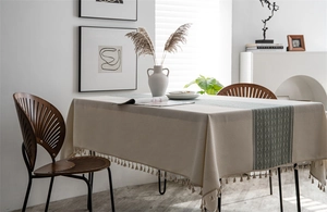 Detail of beige geometric jacquard tablecloth with textured fringes in Nordic style