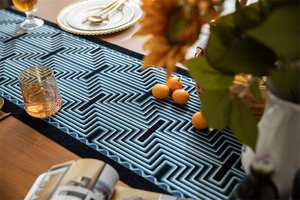 Close-up of blue geometric jacquard table runner on a wooden table with dining decor