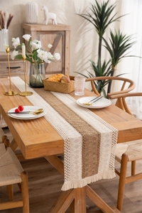 Close-up of rustic cotton linen table runner with tassel fringe and lace details