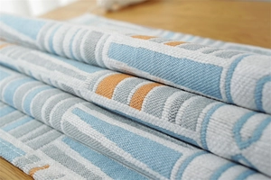 Close-up of geometric jacquard dust cover fabric showing blue and orange woven texture