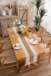 Close-up of bohemian linen table runner featuring striped patterns and fringed tassels