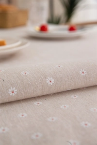 Close-up of beige table cloth showing daisy print texture and cotton-linen weaving