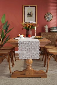 Detail of white hollow floral lace table runner with elegant scalloped edges for weddings