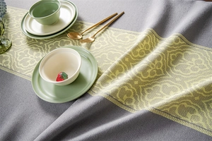 Detail of grey bohemian table runner with yellow geometric pattern and tassels