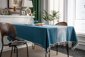 Close-up of blue mandala table cloth with elegant white fringe tassels and textured fabric