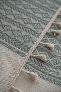 Close-up of geometric diamond pattern and handmade fringe on a bohemian table runner
