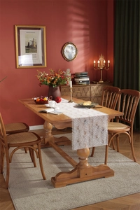 Close-up of white lace table runner with elegant rose patterns on a wooden dining table