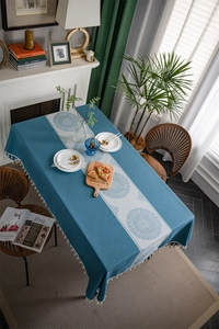 Detail of blue sun flower jacquard tablecloth with mandala patterns and white fringe edge