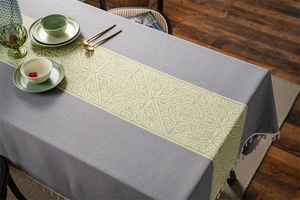 Close-up of jacquard table cloth with floral patterns and white fringe tassel details