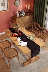 Detail of elegant black lace table runner with hollow floral patterns on a wooden table