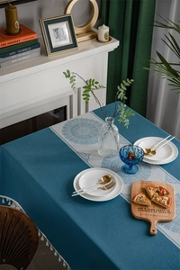 Close-up of blue floral jacquard tablecloth with white tassel edge and mandala pattern