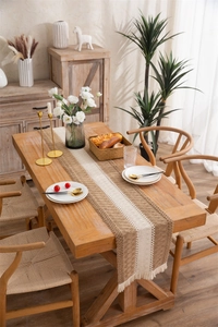 Close-up of bohemian linen table runner with geometric patterns and fringe tassels