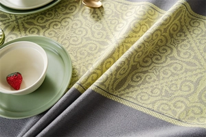 Detailed view of jacquard floral patterns and thick fabric texture on a dining tablecloth