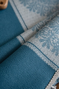 Close-up of blue sunflower jacquard fabric texture with woven tassel edge detail