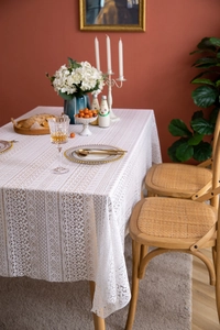 Close-up of French lace tablecloth with hollow flower patterns and scalloped edges
