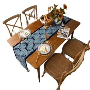Navy blue geometric jacquard table runner with fringe tassels on solid wood table