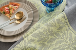 Detailed view of jacquard grey leaf pattern fabric with lace edge and vibrant yellow accents