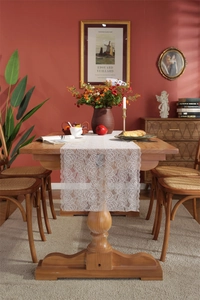 Close-up of white French lace table runner with intricate rose floral patterns and wavy edges