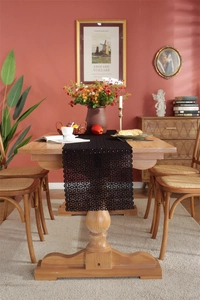 Detail view of black floral lace table runner with intricate hollow cut-out patterns