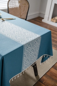 Detailed view of jacquard pattern and white fringe on the gray blue tablecloth