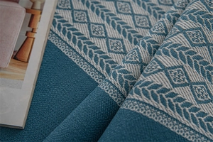 Close-up of blue and white geometric woven jacquard fabric texture with herringbone pattern
