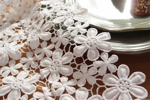 Close-up of white 3D flower lace table runner with intricate hollow floral embroidery